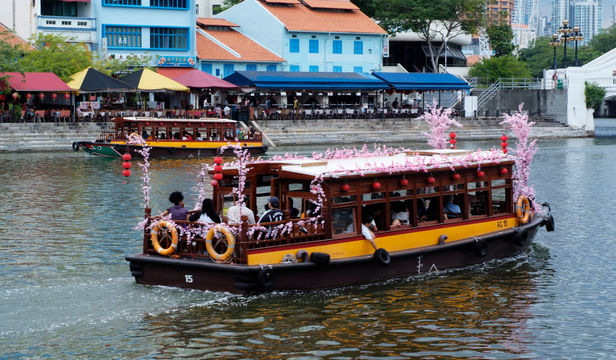 Serene cruise ship gliding through Singapore River, offering passengers a delightful journey with captivating scenic views and joyful moments.